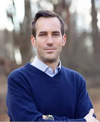Randall Steketee in a navy sweater, arms crossed